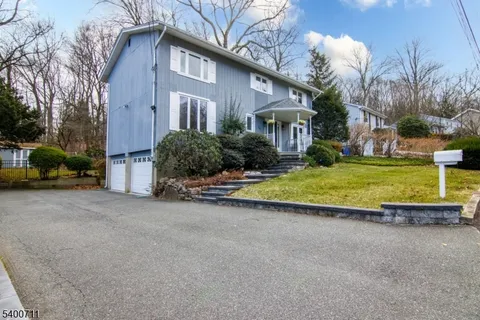 a view of a house with a yard and a large tree