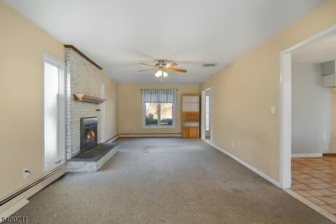 a view of an empty room with a fireplace and a window