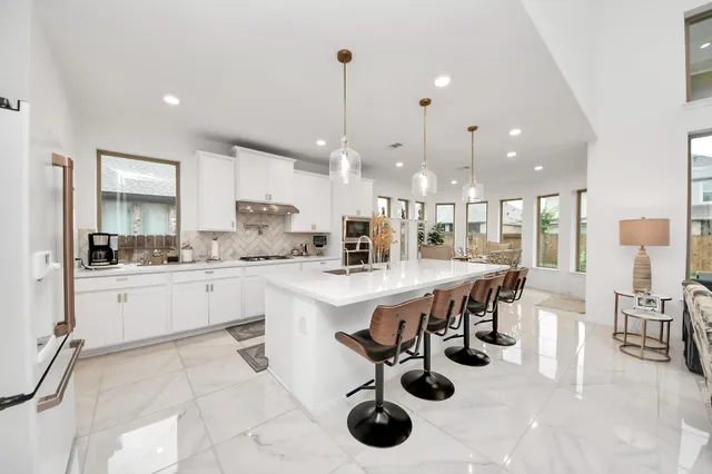 a kitchen with stainless steel appliances kitchen island granite countertop a large island in the center