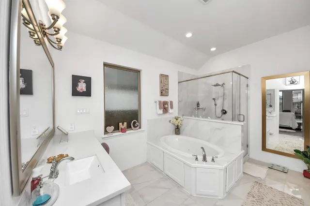 a bathroom with a tub a sink and a shower