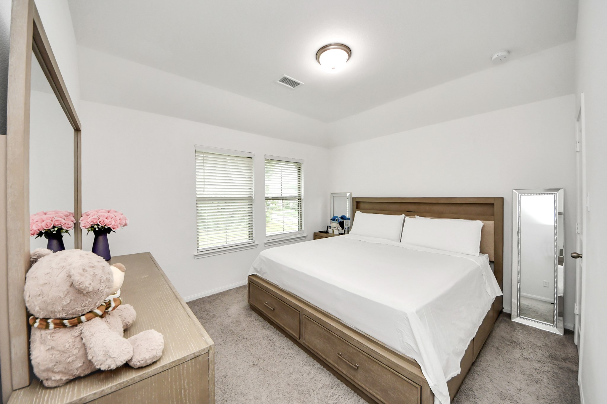 14948 Galileo Gates Drive Conroe, TX 77302 - Photo 24 of 30 a large white bed sitting in a room next to a window and a chandelier