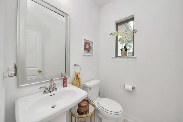 a bathroom with a toilet a sink and mirror