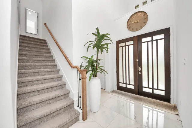a view of staircase with a large window and a potted plant