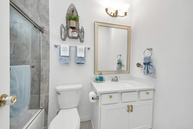a bathroom with a toilet sink and mirror