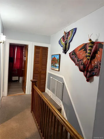 a view of a hallway and an entryway with wooden floor