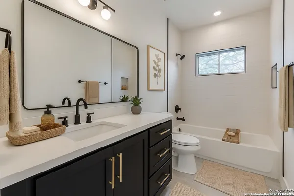 a bathroom with a double vanity sink toilet and a mirror