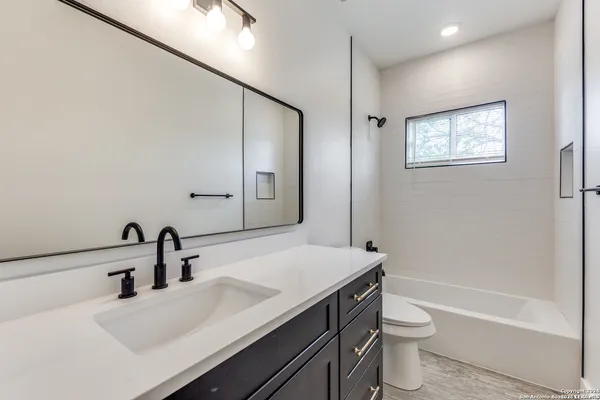 a bathroom with a sink a toilet and shower
