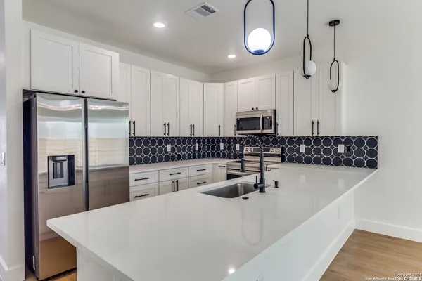 a kitchen with stainless steel appliances a refrigerator sink and stove