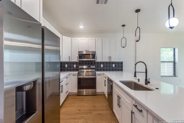 a kitchen with a sink cabinets and stainless steel appliances