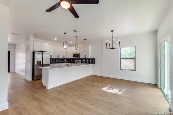 a view of kitchen with ceiling fan refrigerator and window