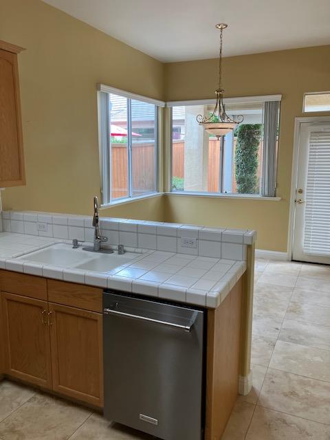 2157 West Rue St Michel Fresno, CA 93711 - Photo 9 of 22 a kitchen with a sink a chandelier and wooden floor