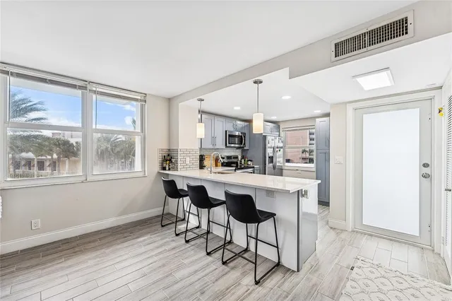 a kitchen with stainless steel appliances granite countertop a refrigerator a stove a sink and a microwave