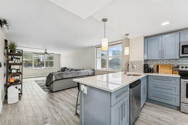 a kitchen with stainless steel appliances kitchen island granite countertop a table and chairs in it