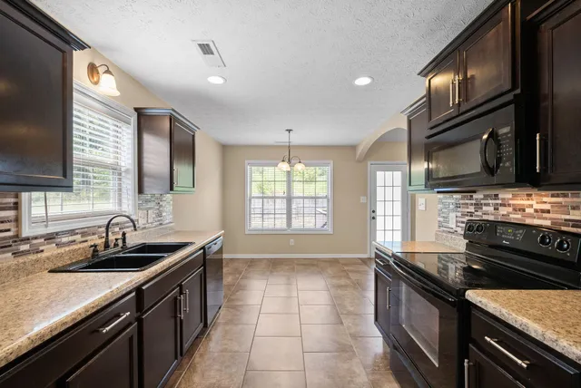 a kitchen with a sink stove and microwave
