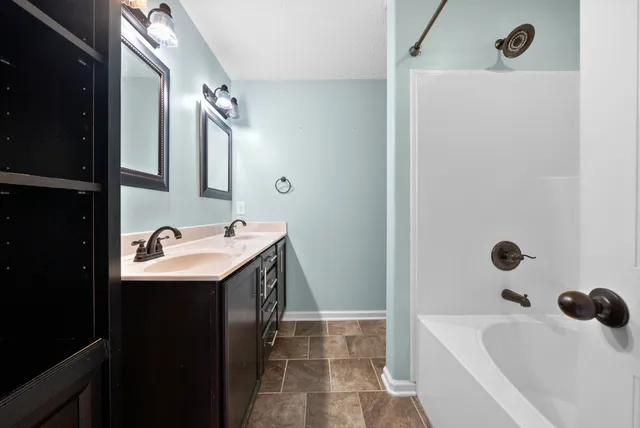 a bathroom with a tub sink and mirror