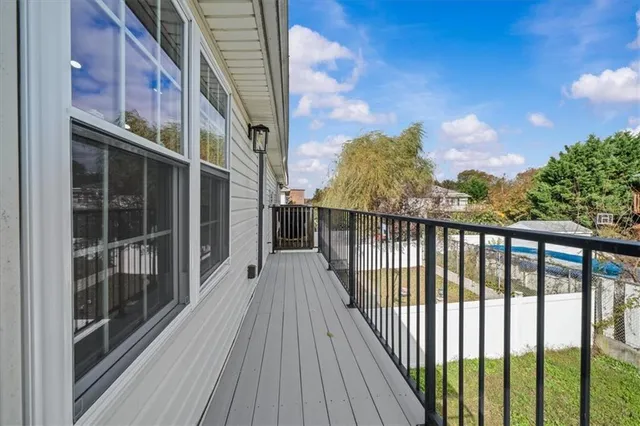 a view of a balcony with wooden floor and fence