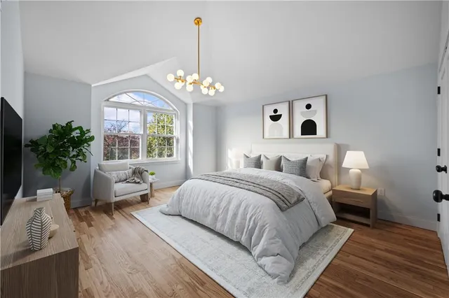 a spacious bedroom with a bed and a chandelier