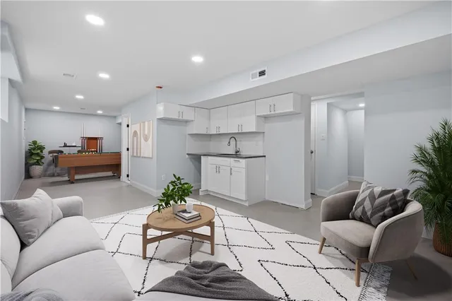 a living room with furniture and kitchen view