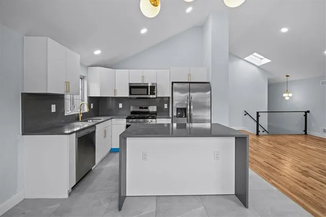 a large kitchen with stainless steel appliances lots of counter space and a sink