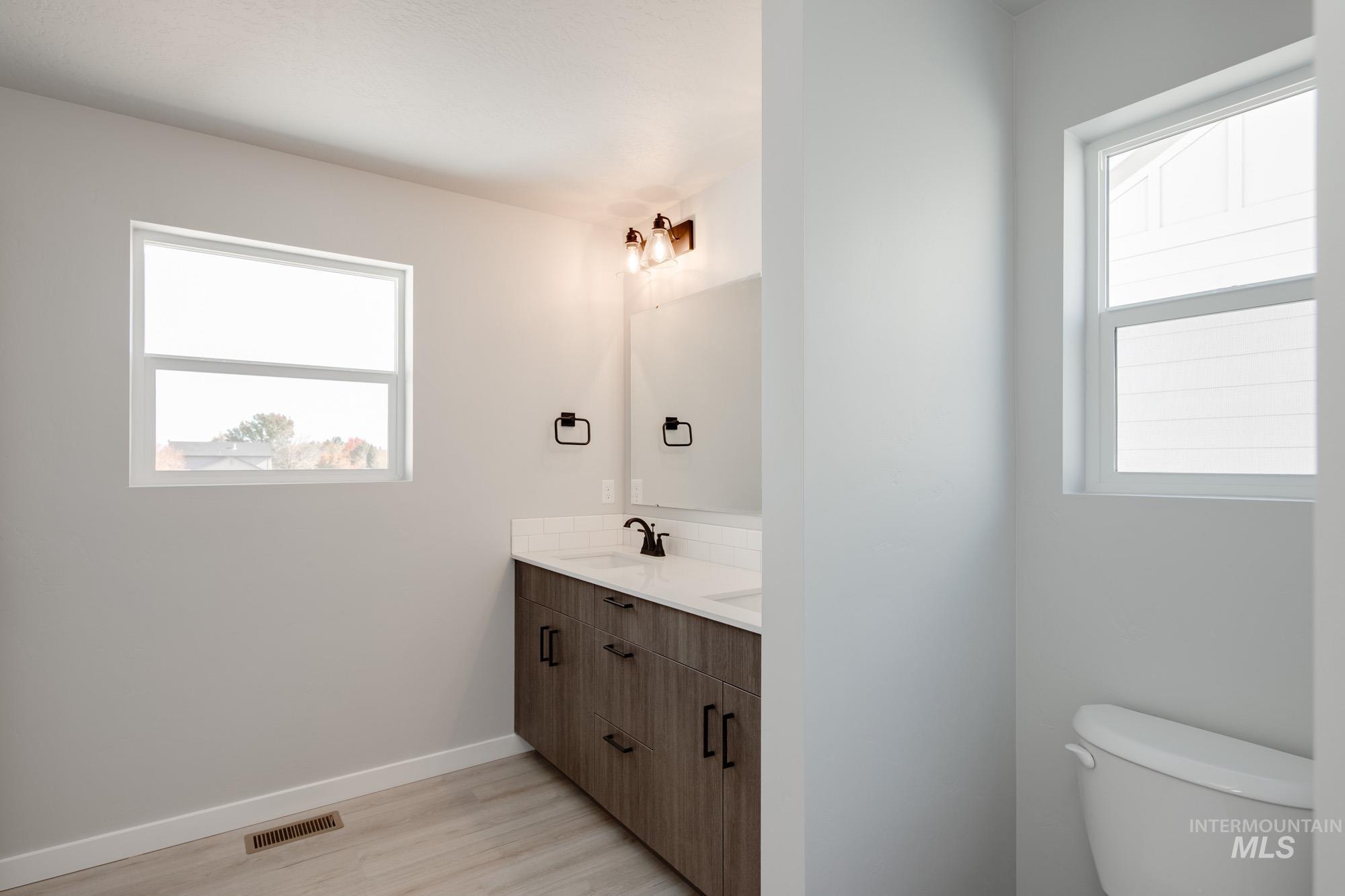 2058 South Border Way Meridian, ID 83642 - Photo 17 of 25 Full bathroom featuring double vanity, light wood finished floors, and plenty of natural light