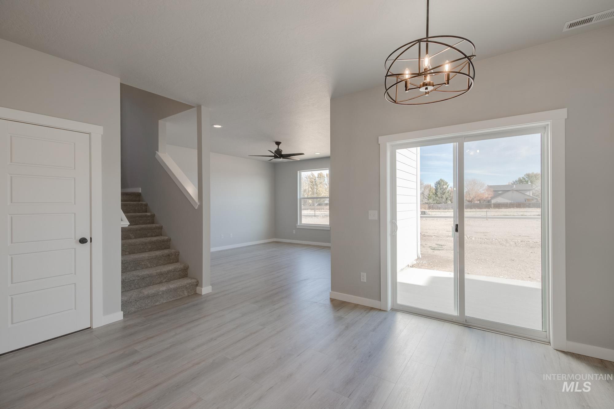 2058 South Border Way Meridian, ID 83642 - Photo 9 of 25 Unfurnished dining area featuring hanging lights, a ceiling fan, and light wood-type flooring