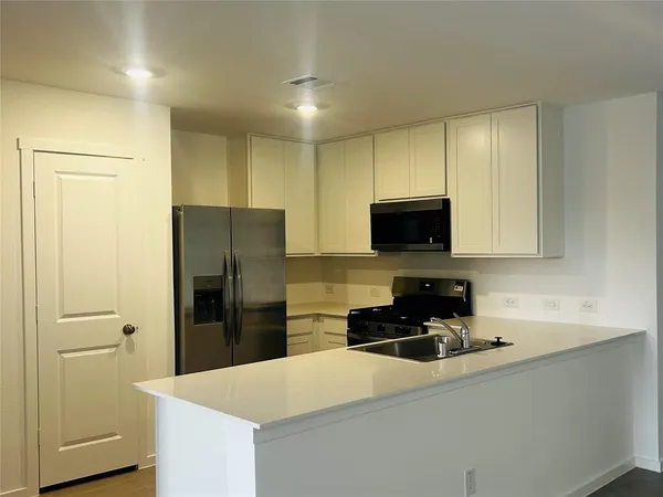 a kitchen with a refrigerator a stove and a sink