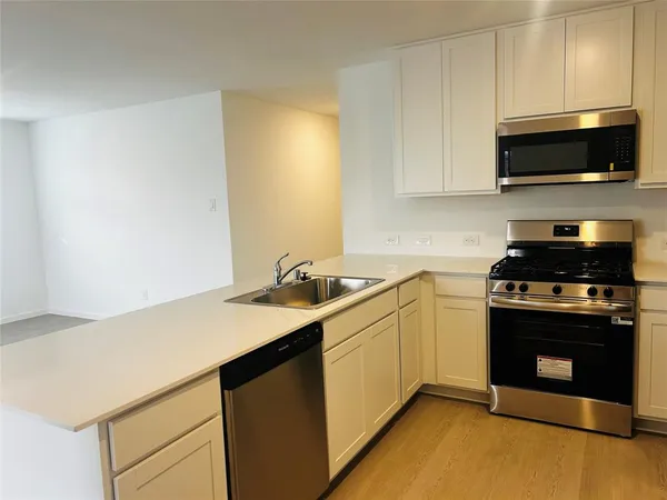 a kitchen with stainless steel appliances a stove a microwave and sink