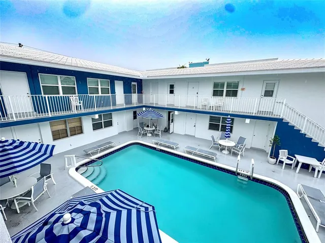 a view of a patio with table and chairs with wooden floor and fence