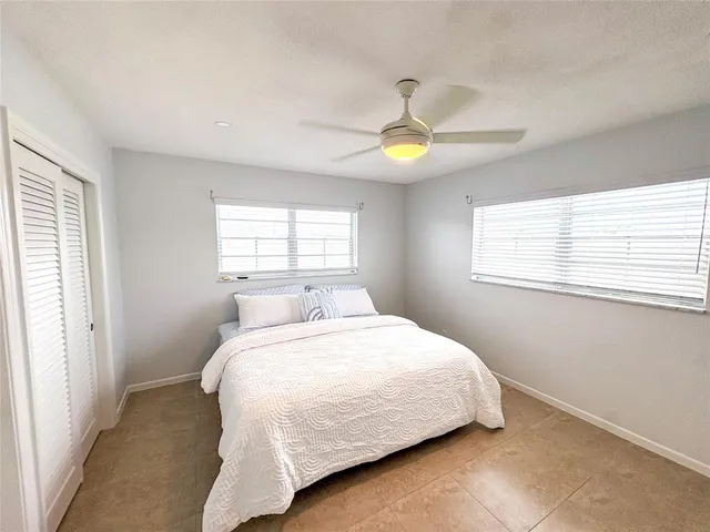 a bedroom with a bed window and a flat screen tv