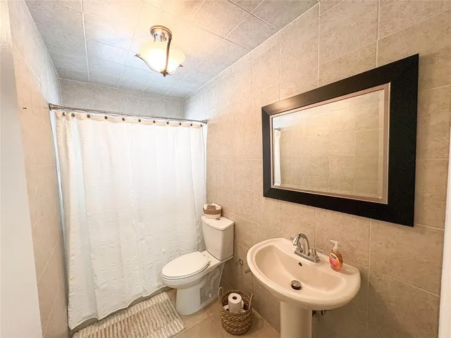 a bathroom with a sink toilet and a mirror