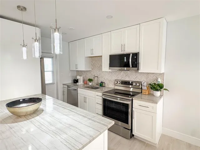 a kitchen with a stove a sink and a refrigerator