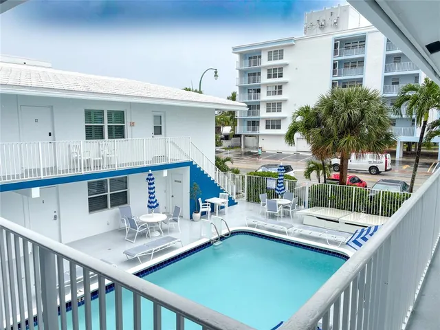 an aerial view of residential houses with yard and mountain view in back