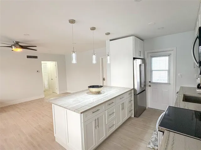 a kitchen with a sink stove top oven and cabinets
