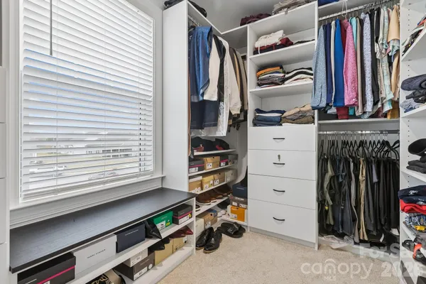 a view of walk in closet with clothes and shoes