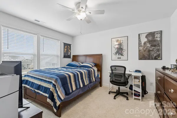 a bedroom with a bed desk and chair