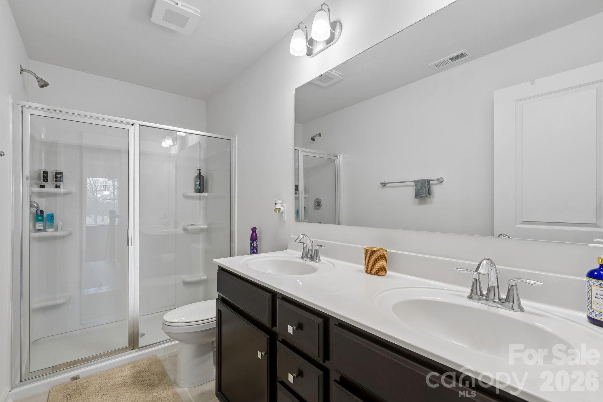 911 Cypress Point Lane Monroe, NC 28112 - Photo 29 of 37 a bathroom with a granite countertop sink a toilet a shower and a mirror