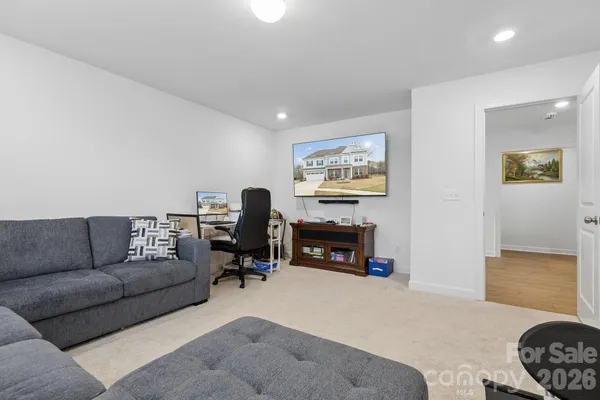 a living room with furniture and a flat screen tv with a fireplace