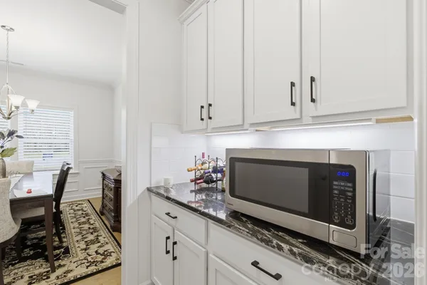 a kitchen with granite countertop white cabinets and white appliances