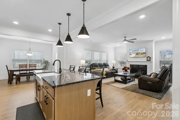 a kitchen with stainless steel appliances granite countertop sink stove and living room view