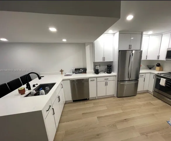 a kitchen with a sink a refrigerator and cabinets