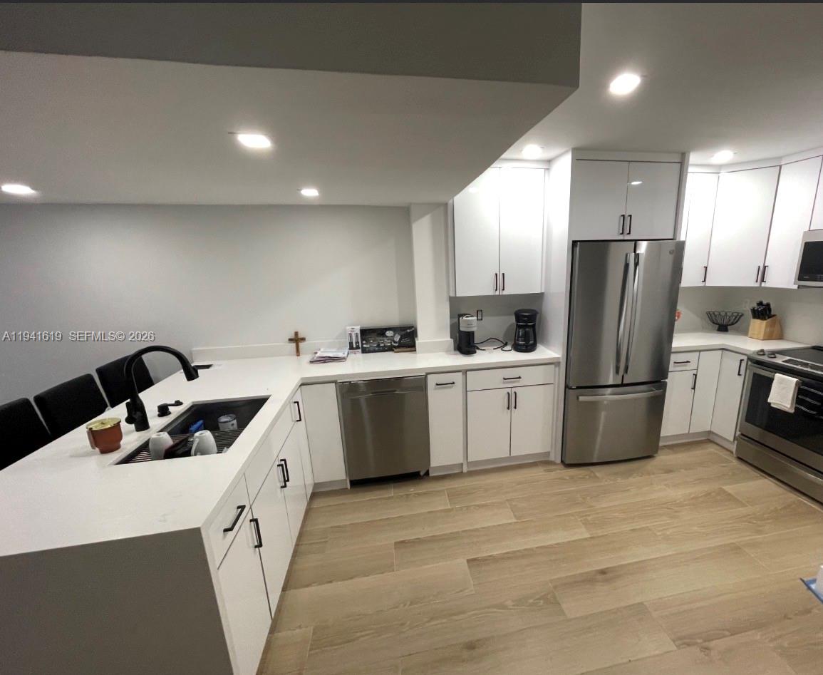 15103 Southwest 81st Street, Unit 213 Miami, FL 33193 - Photo 3 of 13 a kitchen with a sink a refrigerator and cabinets