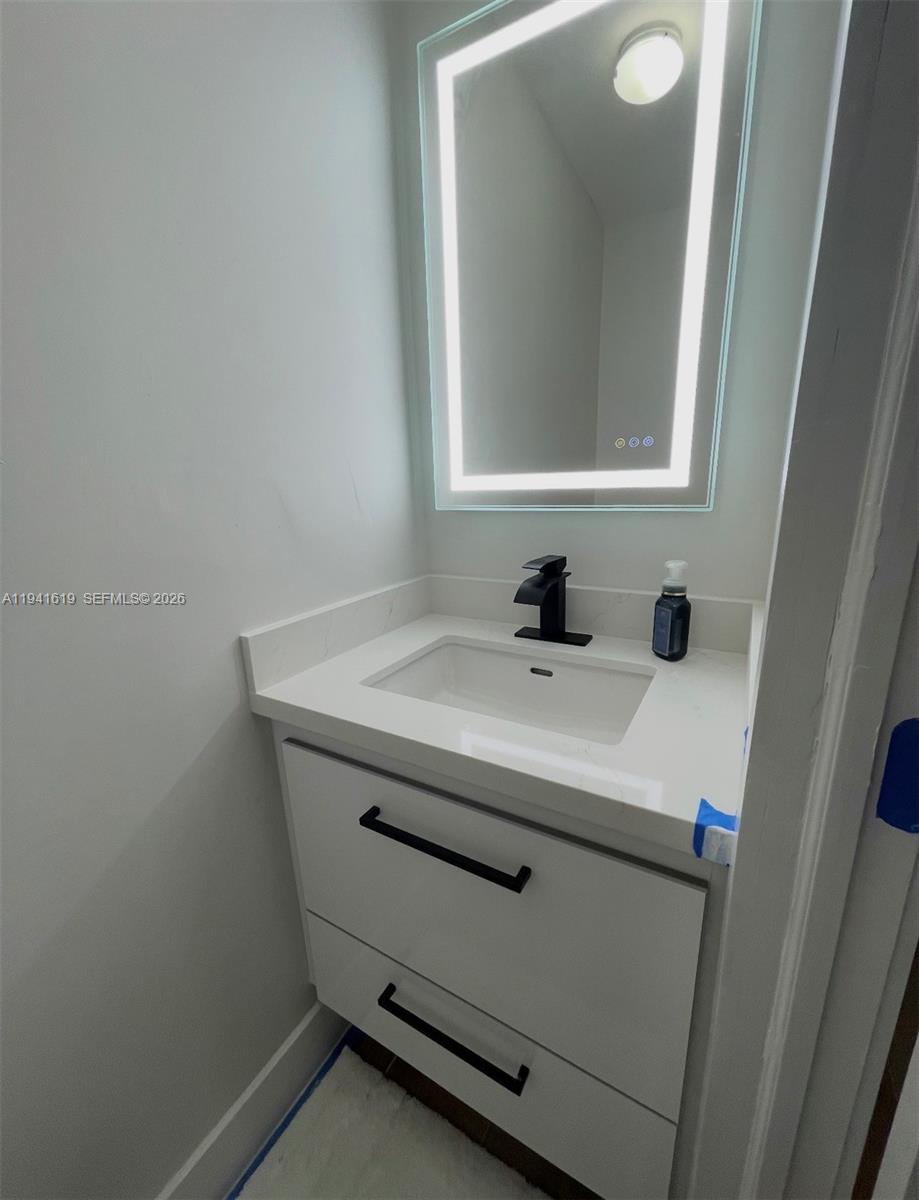15103 Southwest 81st Street, Unit 213 Miami, FL 33193 - Photo 5 of 13 a bathroom with a sink and a mirror