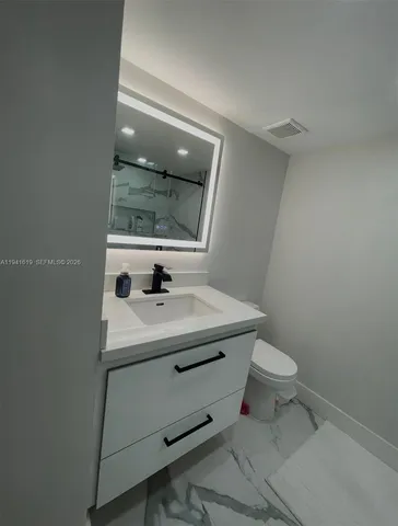 a bathroom with a sink toilet and mirror