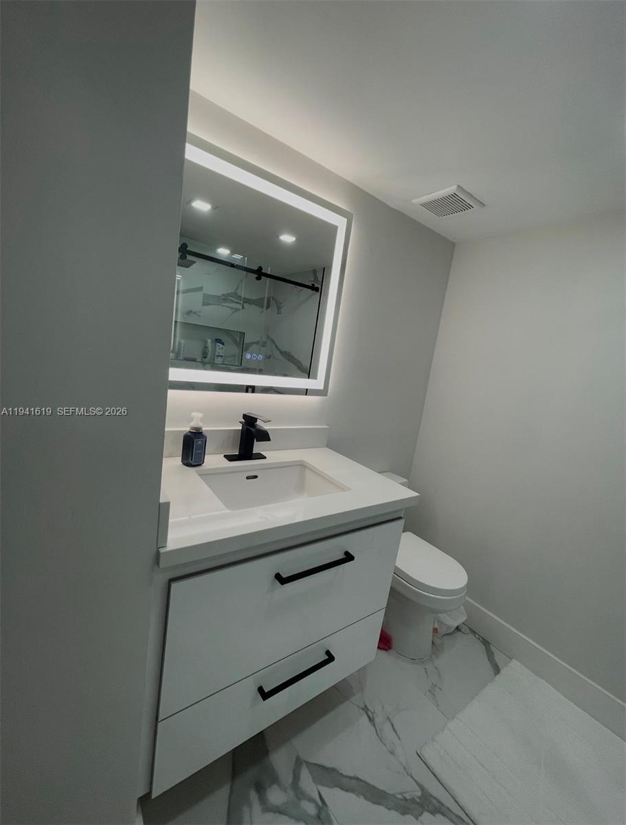 15103 Southwest 81st Street, Unit 213 Miami, FL 33193 - Photo 9 of 13 a bathroom with a sink toilet and mirror