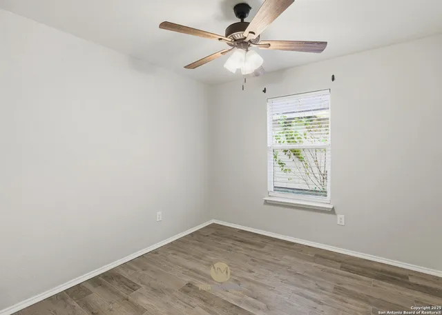 an empty room with a window and a fan