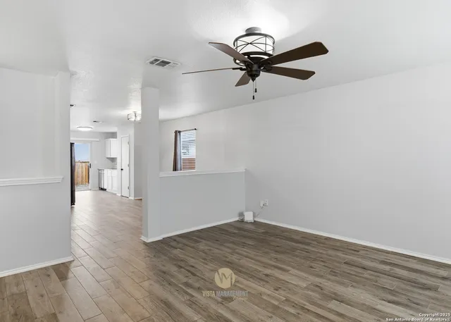 a view of empty room with wooden floor and window