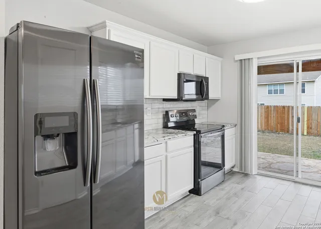a kitchen with a refrigerator and a stove top oven