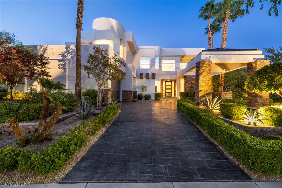 2000 Grouse Street Las Vegas, NV 89134 - Photo 67 of 89 A modern architectural marvel welcomes with a grand, illuminated entrance and meticulous desert landscaping.