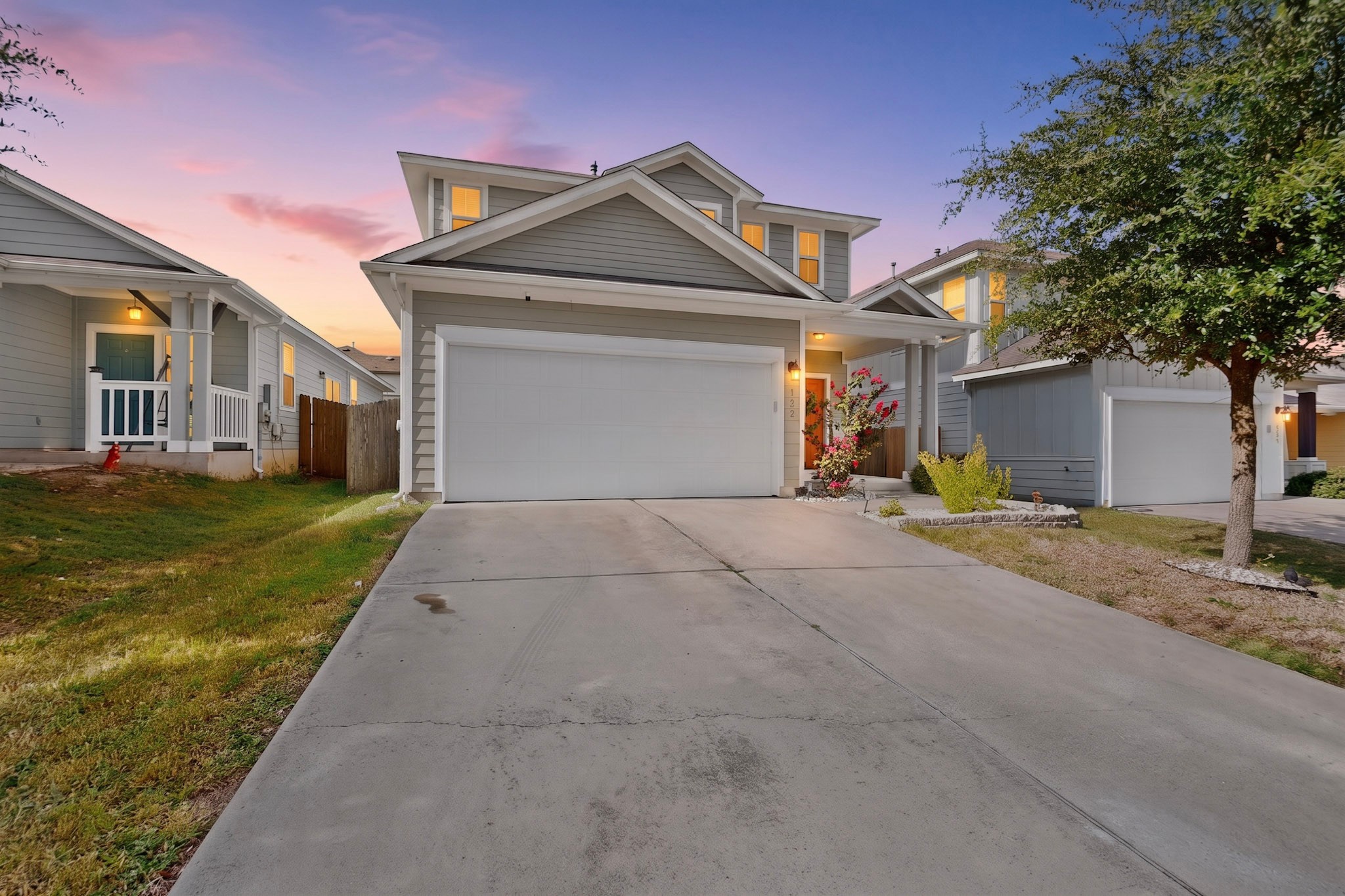 132 Wapiti Road Buda, TX 78610 - Photo 1 of 31 A welcoming facade, blending traditional design with contemporary appeal, beckons under a colorful sunset.