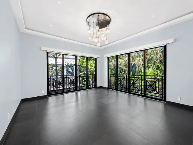 a view of an empty room with wooden floor and a floor to ceiling window